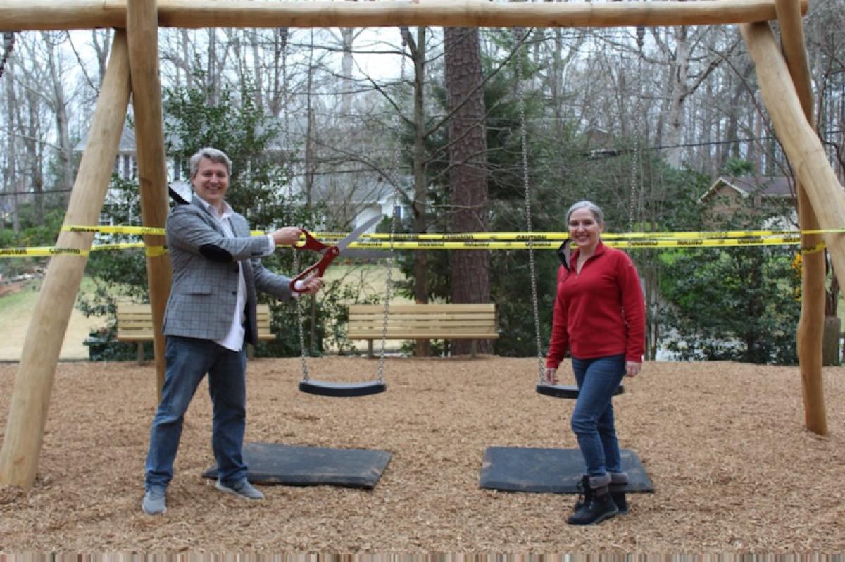 Mayor John Ernst and District 1 Council Member Linley Jones cutting the ribbon on the new playground at Murphey Candler Park